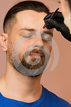Correcting shape of eyebrows to male client