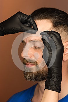 Correcting shape of eyebrows to male client