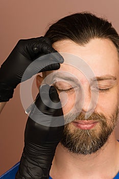 Correcting shape of eyebrows to male client