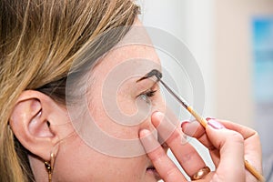 Correction of eyebrow tweezers, eyebrow henna painting, beautiful young girl beauty salon