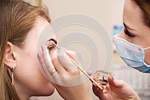 Correction of eyebrow tweezers, eyebrow henna painting, beautiful young girl beauty salon