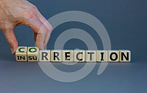 Correction vs insurrection symbol. Businessman turns wooden cubes and changes word `insurrection` to `correction`. Beautiful g