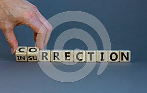 Correction vs insurrection symbol. Businessman turns wooden cubes and changes word `insurrection` to `correction`. Beautiful g photo