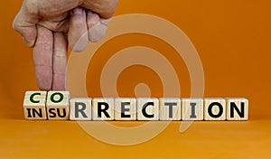 Correction vs insurrection symbol. Businessman turns wooden cubes and changes word insurrection to correction. Beautiful orange photo
