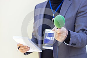 Correspondent holding microphone making media interview