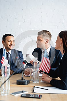 Correspondent with microphone interviewing politician during