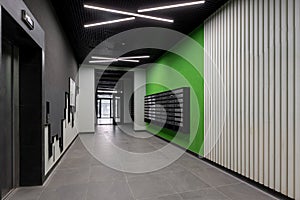 Corridor hall interior, with front door and elevator in many apartment building, with mailboxes with green walls