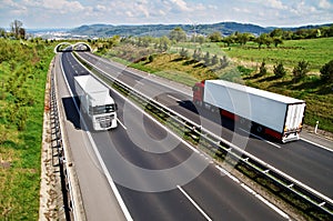 Corridor highway with the transition for animals, going down the highway two trucks