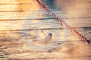 Corridor Lanes and swimmer in swimming pool with fog over the water. Sport Competition