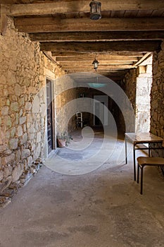 Corridor in medieval house with wooden beams on ceiling. Ancient stone building inside.