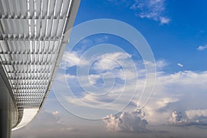 Corridor with modern office building roof with blue sky and whit