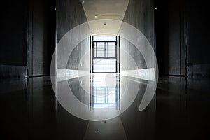 Corridor in an office building with daylight through the windows.  Corridor with black doors  and reflections on the ground  Yello