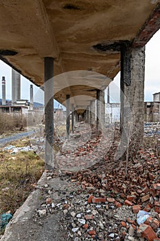Corridor of an old chemical factory looted dilapidated crumbling bricks gravel concrete