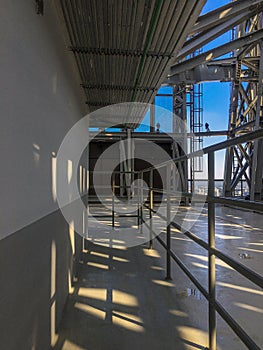 Corridor with rail and conduits on the ceiling on the rooftop of building