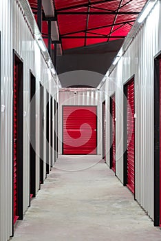 Corridor of self storage unit with red doors. Rental Storage Units