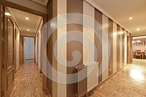 Corridor of an urban residential house with parquet floor and two-tone walls, brown and white