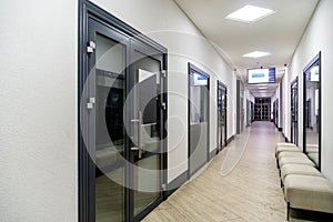 A corridor in an urban-type office building. Modern interior of the lobby of an office building with glass doors and clean white