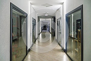 A corridor in an urban-type office building. Modern interior of the lobby of an office building with glass doors and clean white