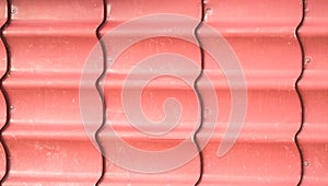 Corrugated corrugated metal sheet, painted in pink, siding for walls and roofs, background, texture