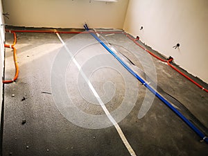 corrugated electric cables on the concrete floor insulation in a residential building under construction