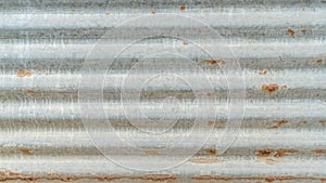 Corrugated galvanized rusty metal sheet background with old aged rust texture on zinc tin or iron steel grunge wall panel