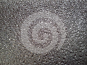 Corrugated glass on a gray background with play of light and shadow