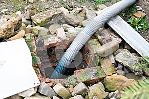 corrugated hose pumping out outdoor septic tank