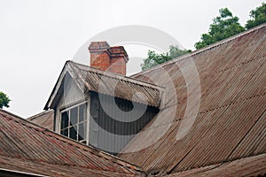 CORRUGATED IRON ROOF OF OLD BUILDING WITH DORMER AND CHIMNEY