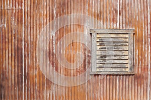 corrugated iron. A texture of corrugated rusty iron wall with wooden window.