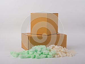 Corrugated parcel boxes with shockproof bubbly plastic protective granules on white background