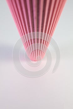 Corrugated pink paper roll on the white desk.