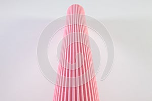 Corrugated pink paper roll on the white desk.