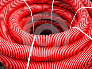 Corrugated pipe, drainage. In the roll, close-up. The tube is corrugated, red.