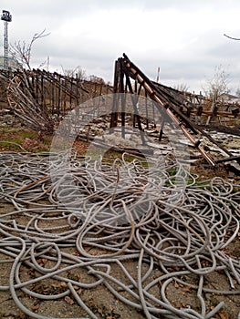 Corrugated pipes for electrical wiring lie in heap on the ground.