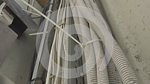 Corrugated sleeve with cable lines at plant or factory indoors. Manufacturing site interior. Part of cement mixing unit.