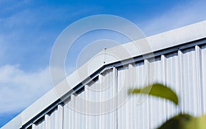 Corrugated steel industrial factory building wall on blue sky with cloud