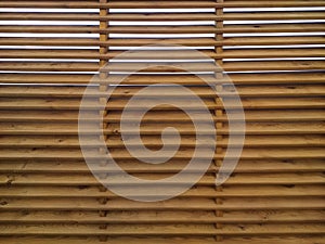 Corrugated wooden fence background with horizontal slats. Texture of wooden boards with holes ideal for placing text and creating