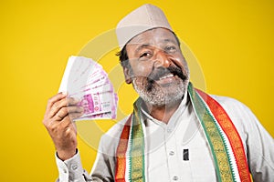 Corrupt greedy indian politician laughing by using money like a fan - concept showing of political arrogance, evil laughter and