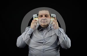 The corrupt official puts wads of dollars to his ears, symbolizing that he did not hear anything. Bribe to an official