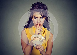 Corrupt, secretive woman with euro money showing shhh sign