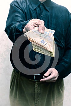 Corrupted businessman, or politician, offering a Hryvnia banknotes bribe