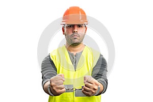 Corrupted male constructor in handcuffs wearing work attire