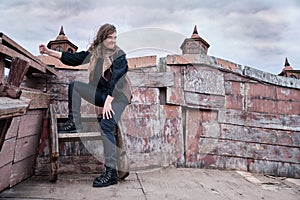 Corsair woman with a knife on board a wooden ship against a gloomy sky on Halloween