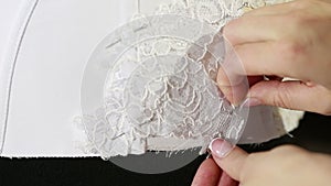 Corset lacing in the manufacturing plant underwear. Manufacture of underwear, tying lace corset seamstress. white corset