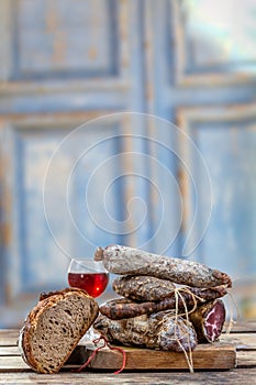 Corsican specialities appetizer: delicatessen, and cheese made in Corsica over old blue wooden background, with a glass