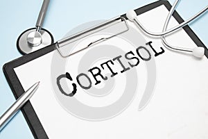 Cortisol glucocorticoid hormone diagnostic concept photo. Figure of adrenal glands with stethoscope, lab test tubes, note labeled