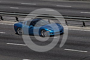 Corvette blue speeding on empty highway