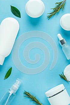 Cosmetic background with white tubes and jars for beauty spa. Flat lay blue color