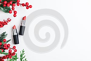 Cosmetic beauty product for professional holiday makeup for Christmas. Red lipsticks in the form of a gift with xmas decor top