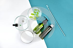 Cosmetic bottle containers with green herbal leaves, Blank label for branding mock-up, Natural beauty product concept.